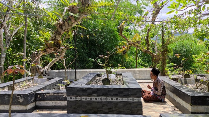 ZIARAH: Septian Alfath, santri asal Tegalombo, Pacitan, tahlilan di makam sesepuh Pondok Pesantren Tremas. (NUR CAHYONO/ JAWA POS RADAR PACITAN)