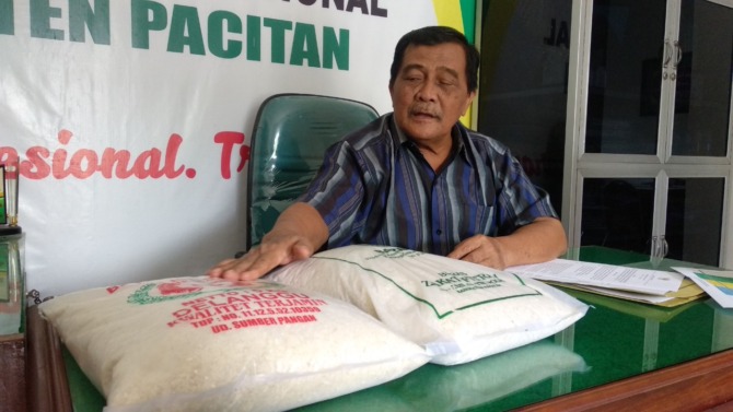 RUKUN ISLAM KEEMPAT: Shodiq Suja menunjukkan beras yang digunakan masyarakat untuk membayar zakat. (SUGENG DWI N./JAWA POS RADAR PACITAN)