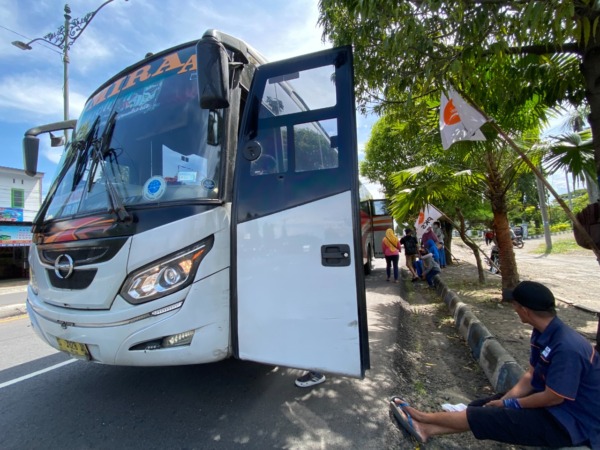 TUNGGU: Sejumlah calon penumpang sedang menunggu kedatangan bus di depan terminal Caruban. (M.R. AKROMU NIAM/JAWA POS RADAR CARUBAN)