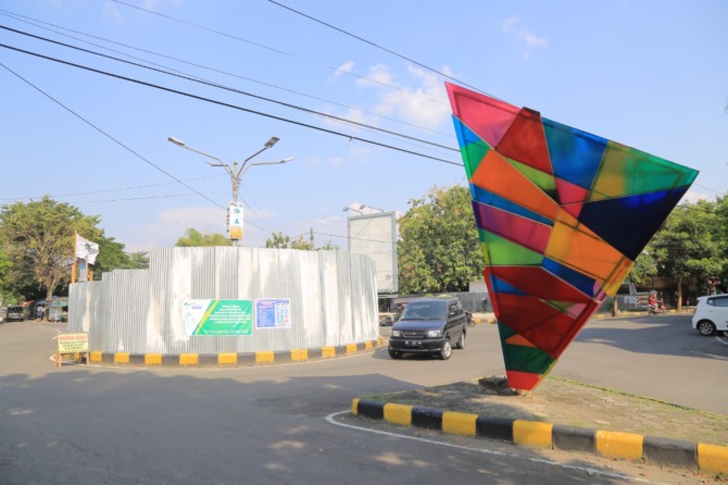 DITUTUP: Bundaran di simpang lima Jalan Serayu sudah ditutup seng untuk persiapan memasang decoration lighting. (BAGAS BIMANTARA/JAWA POS RADAR MADIUN)