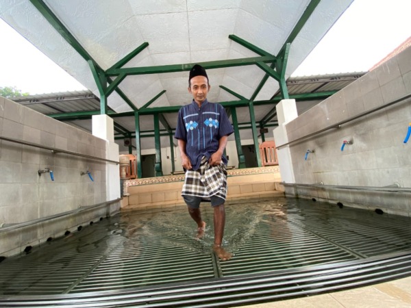 BERSEJARAH: Seorang jemaah sedang keluar dari gapura masjid Sewulan. (M.R. AKROMU NIAM/JAWA POS RADAR CARUBAN)