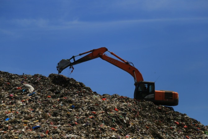 OVERLOAD: Alat berat dikerahkan untuk meratakan tumpukan sampah yang menggunung di TPA Winongo. (BAGAS BIMANTARA/RADAR MADIUN)