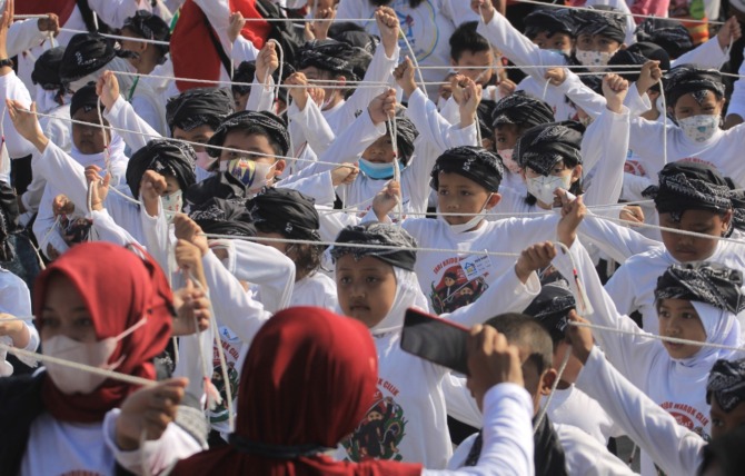 SONGSONG HARI ANAK NASIONAL: Belasan ribu anak menampilkan tarian krido warok cilik di Alun-Alun Ponorogo kemarin. (AJI PUTRA/JAWA POS RADAR PONOROGO)