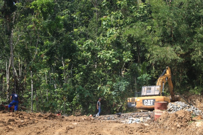 SOLO-PACITAN: Alat berat dikerahkan DPUPR Pacitan untuk meratakan tebing di tepian jalan Sedeng, Pacitan. (SUGENG DWI N./JAWA POS RADAR PACITAN)