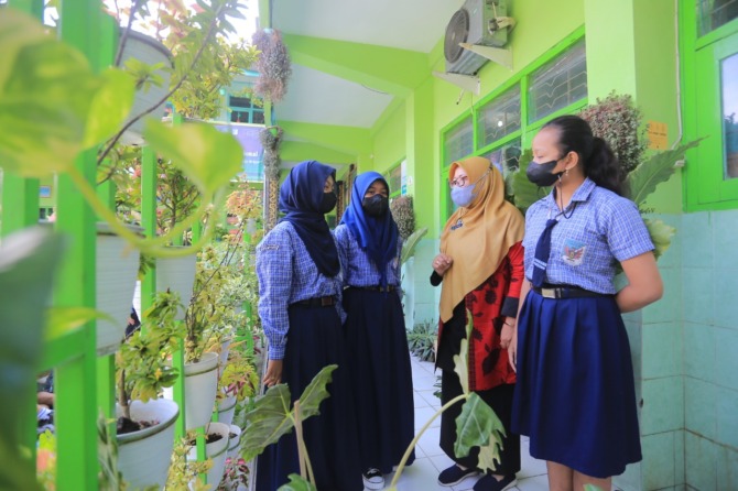 DAFTAR SEKOLAH: Seorang guru menunjukkan laman PPDB Kota Madiun 2022-2023 untuk jenjang SD-SMP yang dapat diakses calon siswa untuk jalur zonasi. (BAGAS BIMANTARA/JAWA POS RADAR MADIUN)