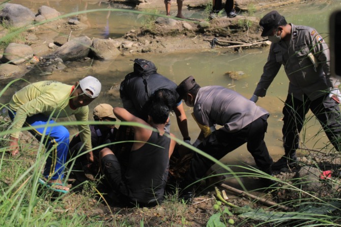 LAKA AIR: Warga mengevakuasi jasad bocah berumur 10 tahun dari Kedung Cumpleng, Sungai Galok, Prajegan, Sukorejo, Jumat (1/7). (AJI PUTRA/RADAR PONOROGO)