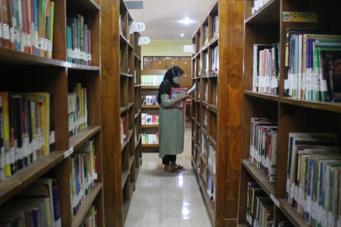 TAMAN PENGETAHUAN: Pengunjung sedang memilih koleksi bacaan di Perpusda Magetan. (KRISHNA IRFANY FOR JAWA POS RADAR MAGETAN)
