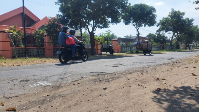MEMBAHAYAKAN PENGENDARA: Penampakan ruas jalan alternatif Madiun-Caruban di Ngadirejo, Wonoasri, yang rusak parah kemarin (20/7). Padahal jalan kabupaten itu baru diperbaiki sekitar setahun lalu. (DIAN RAHAYU/TRAINING JAWA POS RADAR MADIUN)