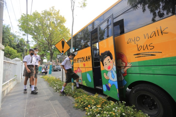 MENGASPAL LAGI: Salah satu armada bus ASG sedang menunggu penumpang di sebuah SMPN. (BAGAS BIMANTARA/JAWA POS RADAR MADIUN)