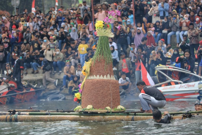 SUROAN: Larung tumpeng Agung di Telaga Ngebel kemarin (30/7). (AJI PUTRA/RADAR PONOROGO)