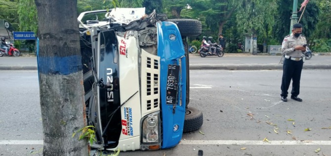 LAKA TUNGGAL: Kondisi Isuzu Elf AG 7638 K yang terguling di Jalan Madiun-Surabaya masuk Desa/Kecamatan Mejayan kemarin (3/7). (UNIT GAKKUM FOR JAWA POS RADAR CARUBAN)