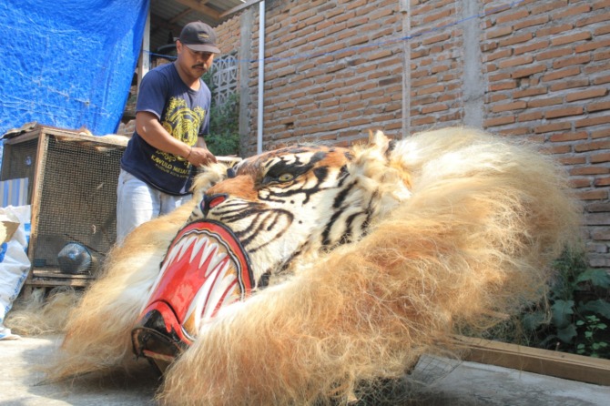 TERAMPIL: Muhammad Wahyu Wibowo sukses menjadi perajin barongan yang dikenal hingga mancanegara. (AJI PUTRA/JAWA POS RADAR PONOROGO)
