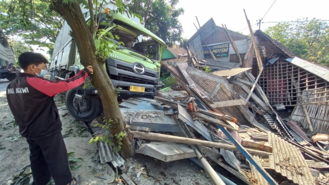 HANCUR: Rumah bengkel di tepi Jalan Raya Ngawi–Caruban masuk Desa Sawo, Karangjati, dihantam truk tronton kemarin. (ASEP SYAEFUL BACHRI/JAWA POS RADAR NGAWI)