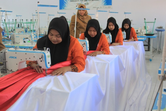 SIAP BERKIBAR: 17 siswi SMKN 2 Ponorogo menjahit bendera raksasa sepanjang 77 meter dan lebar 8 meter. (AJI PUTRA/JAWA POS RADAR PONOROGO)