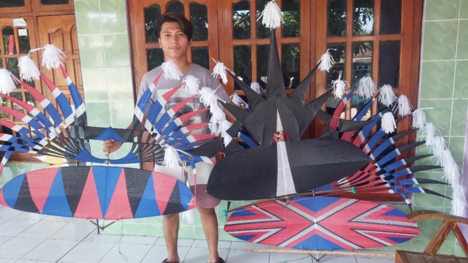 KEARIFAN LOKAL: Rifai sedang membuat kerangka layang-layang pesanan pelanggan. (DIAN RAHAYU PANGASTUTI/JAWA POS RADAR CARUBAN)