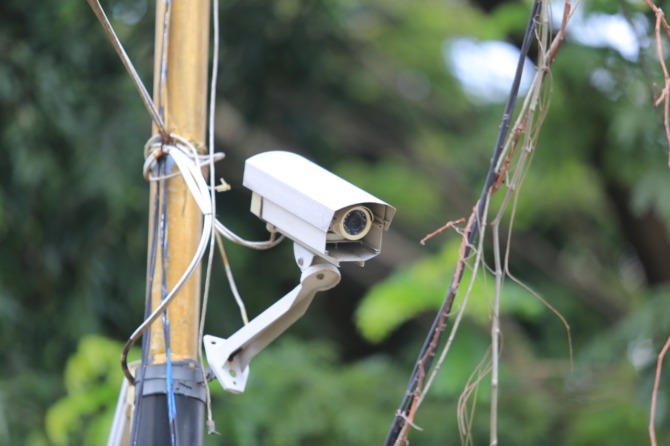 BENAHI: Petugas Disperkim Kota Madiun memeriksa dan memperbaiki CCTV tak berfungsi di kawasan alun-alun. (BAGAS BIMANTARA/JAWA POS RADAR MADIUN)