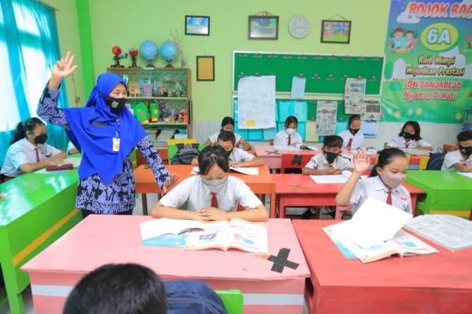 PENDIDIKAN: Seorang guru di Kota Madiun tengah mengajar siswanya di kelas. Pemerintah berencana menghapus pasal TPG di dalam RUU Sisdiknas. (DOK RADAR MADIUN)