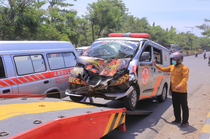 LAKA LANTAS: Mobil ambulans pengantar jenazah ke Ponorogo dievakuasi pascainsiden laka lantas di Jalan Basuki Rahmat, Madiun, kemarin (19/9). (BAGAS BIMANTARA/JAWA POS RADAR MADIUN)