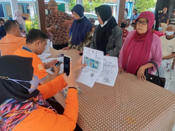 BANSOS: Proses penyaluran BLT BBM kepada penerima manfaat di Kota Madiun yang dilakukan oleh PT Pos Indonesia, Jumat (9/9). (BAGAS BIMANTARA/RADAR MADIUN)