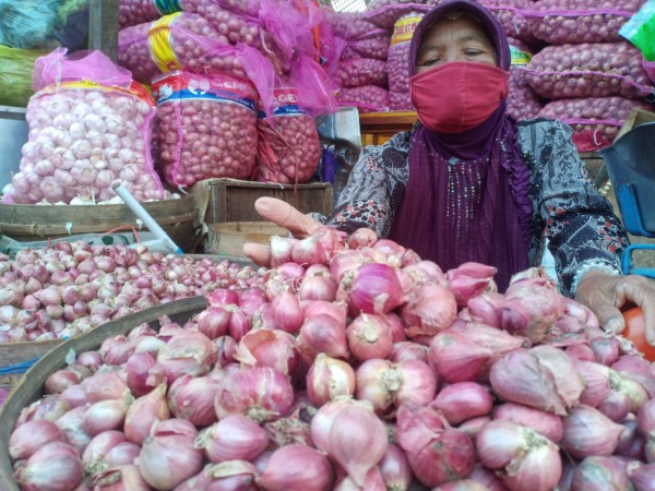 FLUKTUATIF: Pedagang di Pasar Sayur menunjukkan bawang merah yang dijualnya kemarin (12/9). (APRILITA SARI/JAWA POS RADAR MAGETAN)