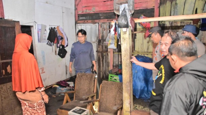 TURUN TANGAN: Bupati Madiun Ahmad Dawami meninjau lokasi bencana puting beliung di Kaligunting, Mejayan, Kamis (8/9) malam. (PROKOPIM FOR JAWA POS RADAR CARUBAN)