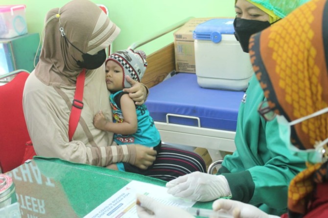 IMUNISASI: Salah seorang anak disuntik vaksinasi di Puskesmas Banjarejo. (RAHMA DWI LESTARI/RADAR MADIUN)
