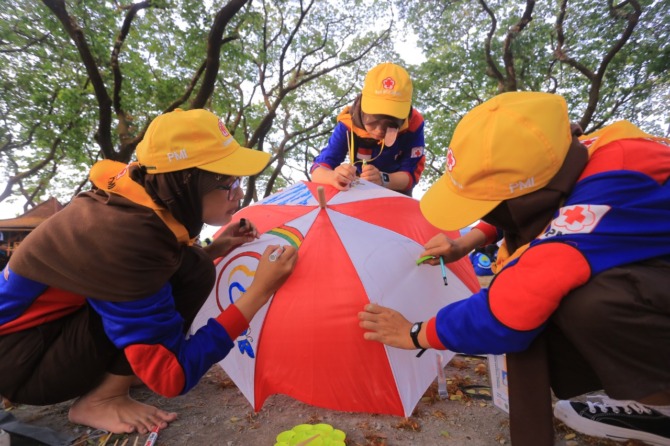 ASAH KREATIVITAS: Melukis payung jadi salah satu lomba yang digelar dalam Jumpa Bakti Gembira PMR Kota Madiun 2022 di Ngrowo Bening kemarin (15/9). (BAGAS BIMANTARA/JAWA POS RADAR MADIUN)