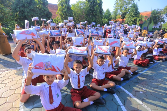 CERIA: Siswa baru salah satu SD di Kota Maidun memamerkan seragam gratis bantuan dari pemkot. (BAGAS BIMANTARA/JAWA POS RADAR MADIUN)