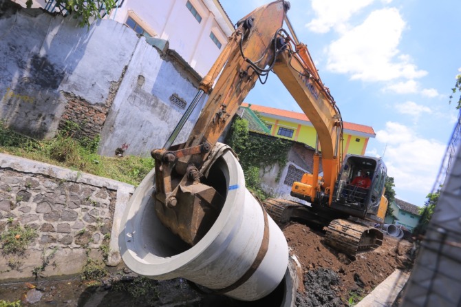 PROYEK BESAR: Sejumlah pekerja kemarin (14/9) menurunkan gorong-gorong di Jalan Pahlawan yang akan dipasang di saluran air Kartini. Di atasnya akan dibangun pedestrian seperti Sumber Umis. (BAGAS BIMANTARA/JAWA POS RADAR MADIUN)