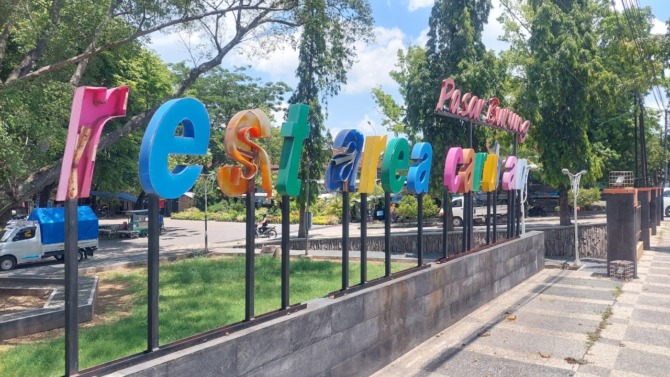 RUSAK: Penampakan besi selokan di pasar burung Caruban yang sudah melengkung dan beberapa huruf nama depan pasar tidak utuh lagi. (DIAN RAHAYU/JAWA POS RADAR MADIUN)