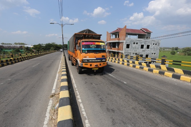 BELUM NYAMBUNG: Suasana ring road barat Kota Madiun kemarin (28/9). Pembebasan lahan untuk megaproyek ring road timur belum bisa direalisasikan tahun ini karena harus menyesuaikan regulasi baru Kemen ATR/BPN. (ILUSTRASI BAGAS BIMANTARA/JAWA POS RADAR MADI