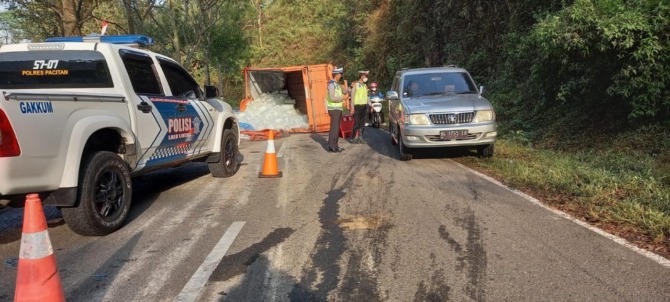 KECELAKAAN TUNGGAL: Truk pengangkut es balok terguling di Jalan Raya Pacitan–Ponorogo kemarin (9/9). (SATLANTAS FOR JAWA POS RADAR PACITAN)
