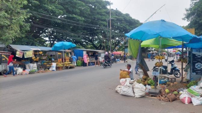 SEMRAWUT: Sejumlah pedagang terpaksa berjualan di pinggir jalan sekitar Pasar Pagotan karena area di dalam sudah penuh. (DIAN RAHAYU/JAWA POS RADAR MADIUN)
