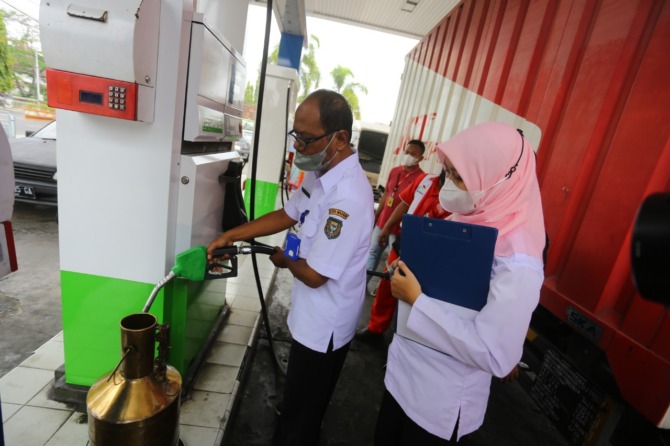 CEK: Petugas UPTD Disdag Kota Madiun melakukan uji tera ulang di SPBU Jalan Yos Sudarso kemarin. (BAGAS BIMANTARA/JAWA POS RADAR MADIUN)