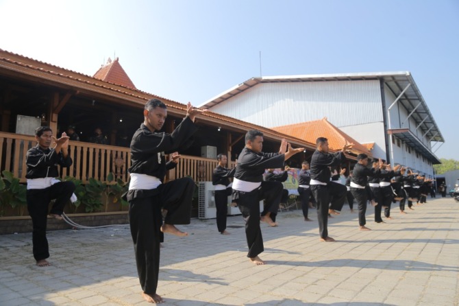 RANCAK: Ratusan warga PSHT menyuguhkan jurus-jurus pencak silat kolosal di Graha Krida Budaya, Padepokan Agung, Nambangan Kidul, Manguharjo, Kota Madiun, kemarin (2/9). (BAGAS BIMANTARA/JAWA POS RADAR MADIUN)