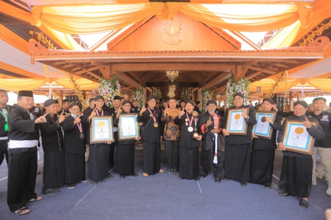 MOTIVASI: Keluarga besar PSHT menerima piagam rekor dari Leprid di Graha Krida Budaya kemarin (2/9). (BAGAS BIMANTARA/JAWA POS RADAR MADIUN)