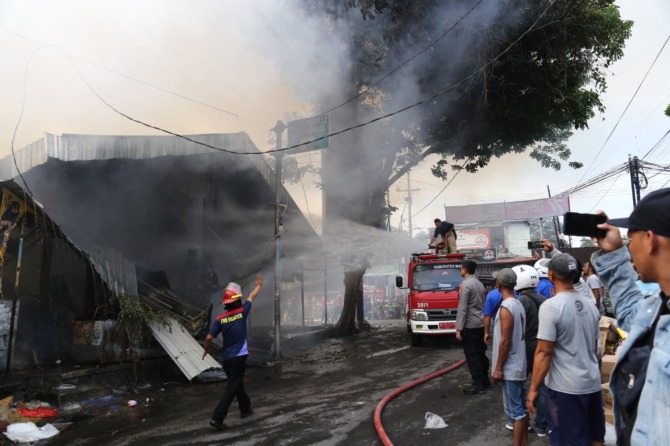 BAGIAN DALAM: Petugas damkar berjibaku memadamkan api yang membakar Pasar Dungus, Wungu, Kabupaten Madiun, kemarin (4/9). (R BAGUS RAHADI/JAWA POS RADAR MADIUN)