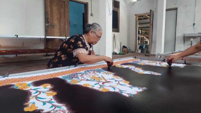 TRADISIONAL: Siti Suwarni sedang menyelesaikan pembuatan batik tulis di galerinya. (DIAN RAHAYU/JAWA POS RADAR MADIUN)