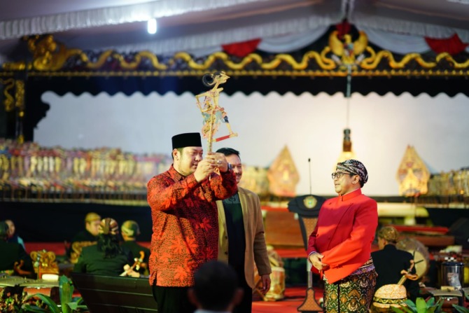 BUDAYA: Ketua DPRD Kota Madiun Andi Raya Bagus Miko Saputra menyerahkan gunungan kepada dalang Ki Warseno Slenk saat pagelaran wayang kulit di lahan kosong depan kantor DPRD Kota Madiun, Jumat (23/9) malam.