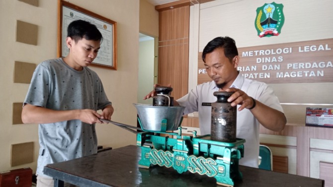 HARUS PAS: Petugas tera ulang di disperindag tengah mengukur alat timbang. (NUR CAHYONO/JAWA POS RADAR MAGETAN)