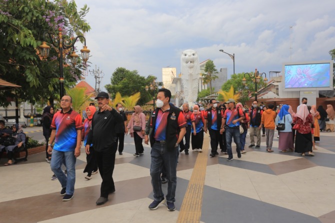 TERKAGUM-KAGUM: Momon Rusmono (kanan) bersama Wali Kota Madiun Maidi (tengah) jalan-jalan di kawasan Sumber Wangi kemarin (23/10). (BAGAS BIMANTARA/JAWA POS RADAR MADIUN)
