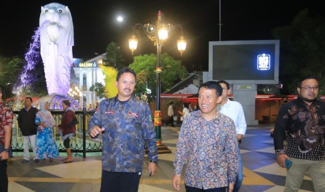 BERKELILING: Wali Kota Madiun Maidi (kiri) dan CEO Jawa Pos Media Leak Kustiya (kanan) berjalan kaki menikmati pemandangan kawasan Sumber Wangi tadi malam. (BAGAS BIMANTARA/JAWA POS RADAR MADIUN)