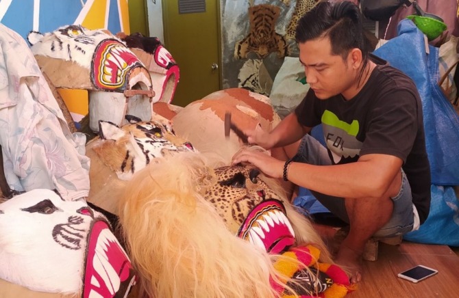 KREATIF: David Riswanto terlihat sedang merapikan barongan reog buatannya. (DAVID RISWANTO FOR JAWA POS RADAR MADIUN)