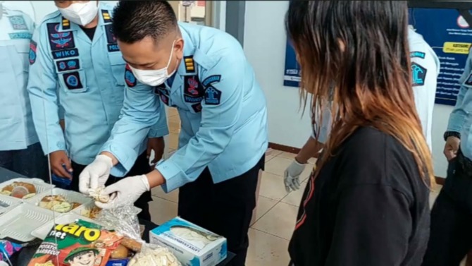 KENA DEH: Petugas dari Lapas Pemuda Madiun memeriksa paket makanan ayam geprek yang dibawa seorang perempuan muda untuk diberikan kepada kekasihnya di dalam tahanan. (ISTIMEWA)