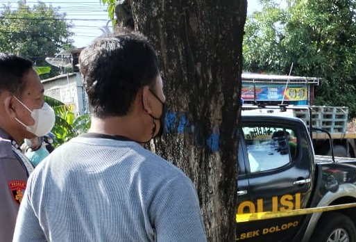 TRAGIS: Petugas saat hendak mengevakuasi jenazah Setu yang meninggal di pinggir jalan Dusun Ngagel, Desa/Kecamatan Dolopo, Kamis (27/10). (ISTIMEWA)