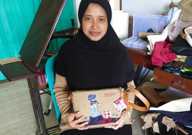 KREATIVITAS TINGGI: Fatmalia Yulinda menunjukkan tas cantik yang dia kreasikan dari kain goni. (ABRIANTO WIBOWO/JAWA POS RADAR MADIUN)