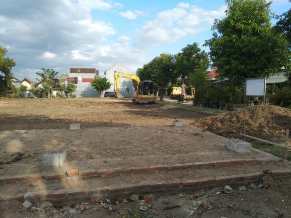 DIREHABILITASI: Satu unit ekskavator tengah meratakan dan memadatkan lapangan Kelurahan Manisrejo, Taman, kemarin (29/10). (RAHMA DWI LESTARI/JAWA POS RADAR MADIUN)