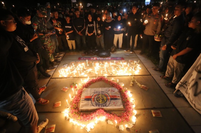 DUKA CITA: Ribuan aliansi suporter sepak bola di Madiun menggelar doa bersama untuk korban tragedi Kanjuruhan di kawasan Stadion Wilis Kota Madiun tadi malam (4/10). (BAGAS BIMANTARA/JAWA POS RADAR MADIUN)