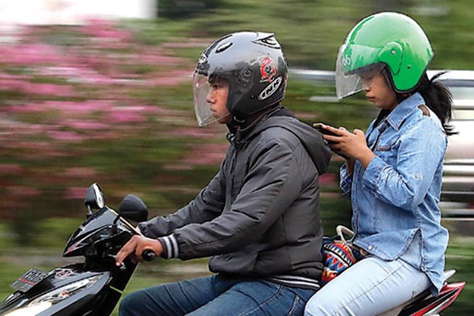Naik sepeda motor dilarang sambil main HP. (ILUSTRASI FOTO: GALIH COKRO/JAWA POS)