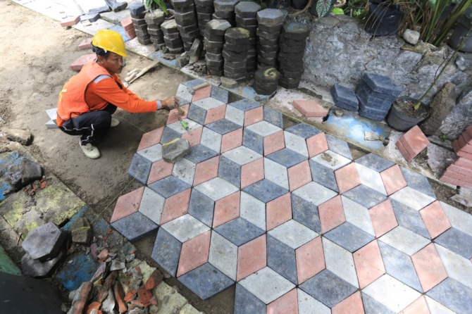 DIGEBER: Pavingisasi Jalan di Kelurahan Pangongangan, Manguharjo, tengah berjalan. Program ini serentak dilaksanakan seluruh kelurahan di Kota Madiun. (BAGAS BIMANTARA/JAWA POS RADAR MADIUN)